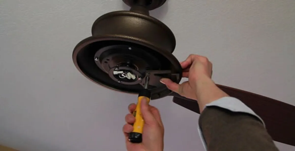 Electrician installing ceiling fan mounting bracket and fixture in Baltimore, MD