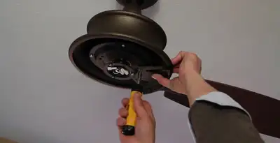 Electrician installing ceiling fan mounting bracket and fixture in Baltimore, MD