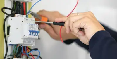 Electrician installing and adjusting circuit breakers in an electrical panel in Baltimore, MD