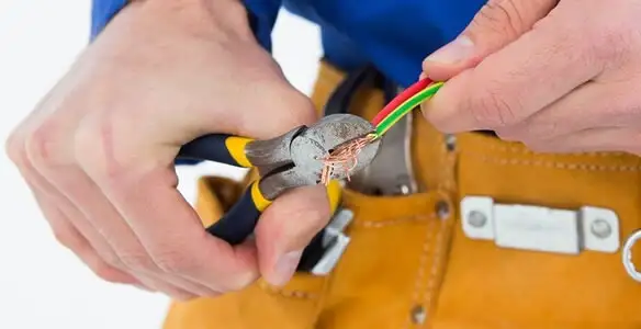 licensed electrician securing electrical wiring with professional tools during service work in Baltimore, MD