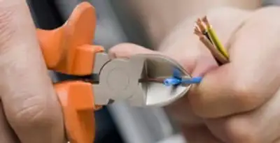 licensed electrician performing precise wire cutting and preparation during electrical service in Baltimore, MD