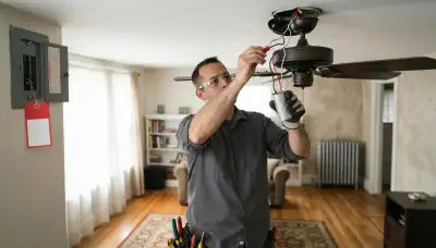 Baltimore electrician replacing a ceiling fan capacitor and reconnecting wiring with power locked off at the breaker