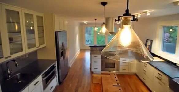 Residential electrician installing modern indoor light fixture in a home in Baltimore, MD